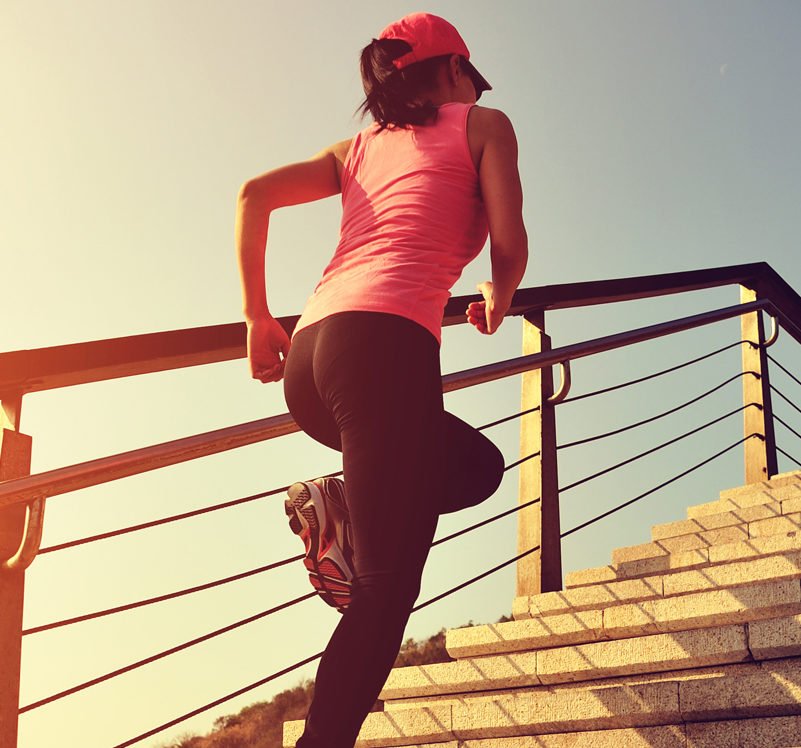 female runner ascending stairs on a sunny day